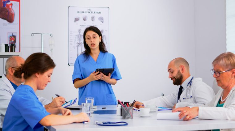 Medical people meeting and planning with shareholders in hospital office Medical people meeting and planning with shareholders in hospital office sitting at desk. Doctors and nurses brainstorm ideas together, physicians diagnosis and presentation data using tablet