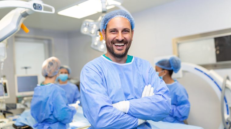 Portrait of male surgeon in operation theater looking at camera. Doctor in scrubs and medical mask in modern hospital operating room. online fellowship courses after mbbs, course for doctors, medical cert online,