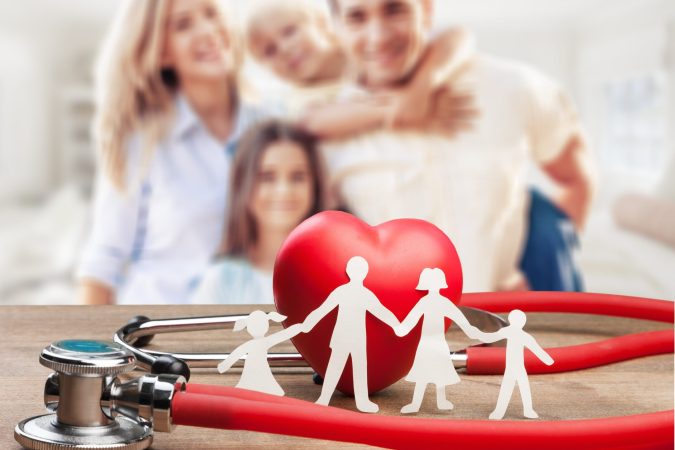 Family cut-out and stethoscope on wooden desk, Medical Insurance Concept